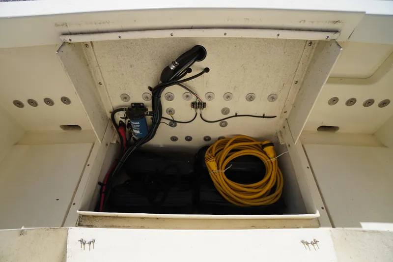 Slide: The Image of 2016 Rosborough 246 Dingby boat compartment with wiring and coiled yellow cable. - 44