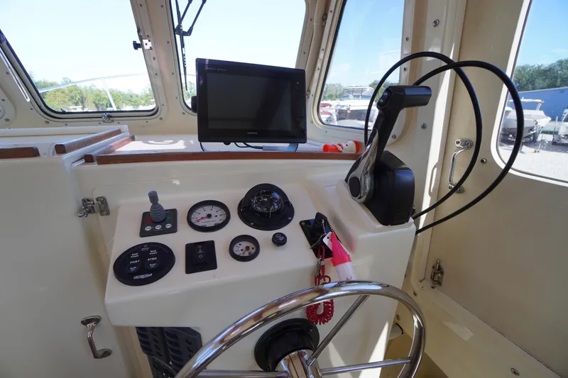 Slide: The Image of 2016 Rosborough 246 Dingby boat helm with steering wheel, controls, and navigation display. - 8