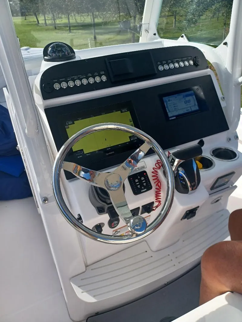 Slide: The Image of 2022 Everglades 243 Center Console boat dashboard with steering wheel and navigation controls. - 11