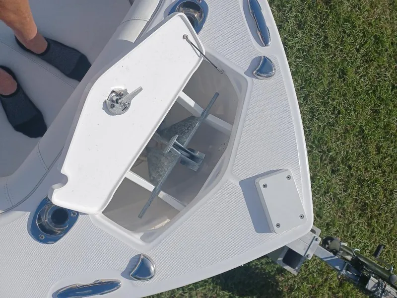 Slide: The Image of Bow anchor compartment of 2022 Everglades 243 Center Console boat on grass. - 19