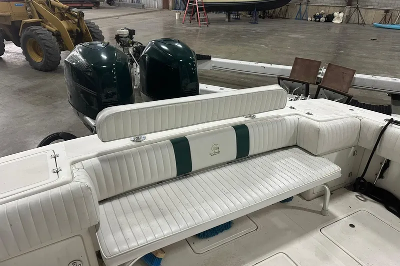 Slide: The Image of 2004 Salt Shaker 30 boat interior with white seating and dual engines in a warehouse. - 15