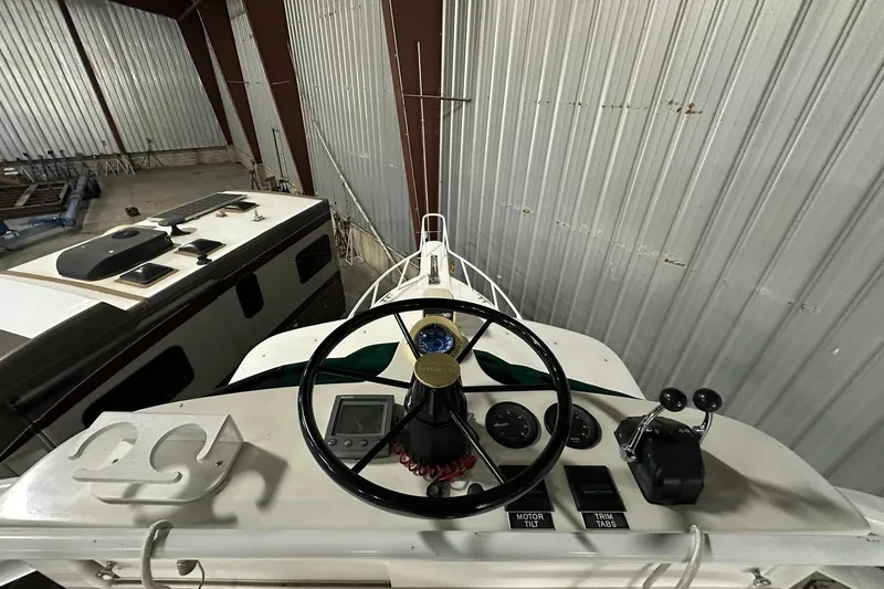 Slide: The Image of 2004 Salt Shaker 30 boat in a warehouse, featuring a dark hull and elevated deck. - 5