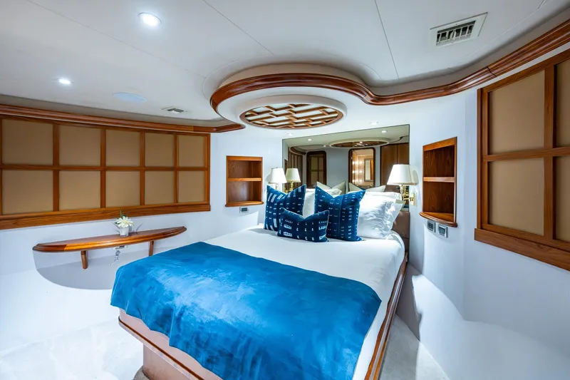 Slide: The Image of Luxurious 2006 Westport 112 yacht bedroom with elegant wood accents and blue bedding. - 58
