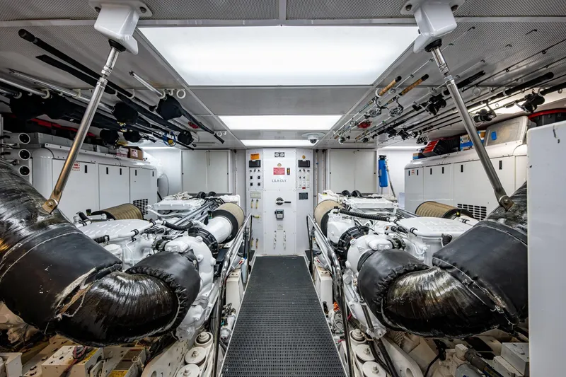 Slide: The Image of Engine room of 2006 Westport 112 yacht, featuring dual engines and organized equipment storage. - 106