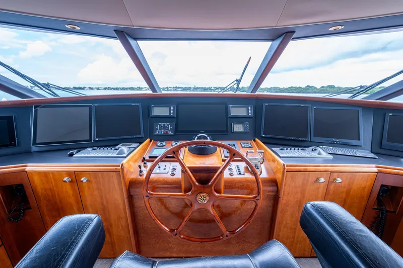 Slide: The Image of Helm of 2006 Westport 112 yacht with wooden steering wheel and multiple navigation screens. - 68