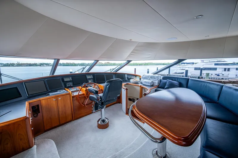Slide: The Image of Luxurious 2006 Westport 112 yacht interior with helm, leather seating, and panoramic windows. - 64