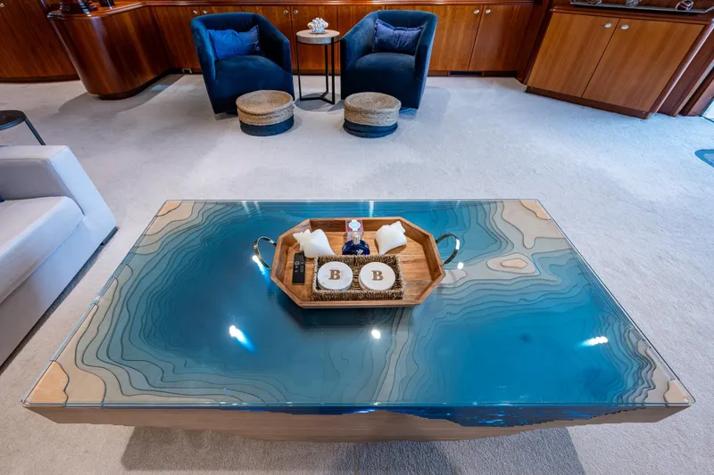 Slide: The Image of Luxurious yacht interior with elegant blue table, wooden accents, and plush seating, Westport 112, 2006. - 5