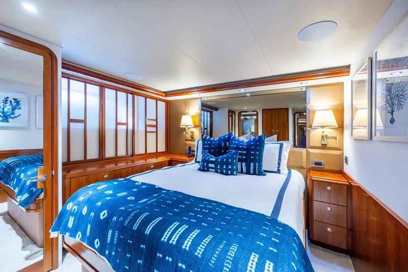 Slide: The Image of Luxurious 2006 Westport 112 yacht bedroom with elegant blue decor and wooden accents. - 52