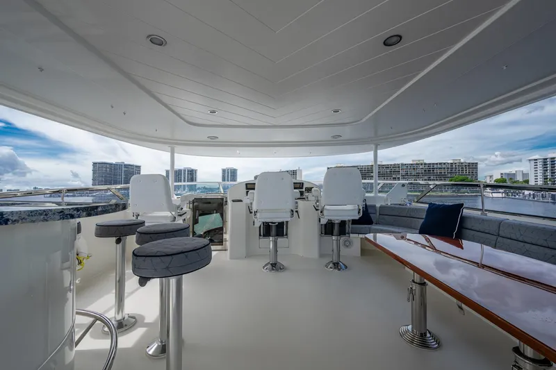 Slide: The Image of Luxurious 2006 Westport 112 yacht deck with seating, bar stools, and cityscape view. - 83