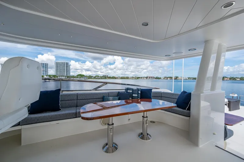Slide: The Image of Luxurious 2006 Westport 112 yacht deck with seating, table, and scenic waterfront view. - 82