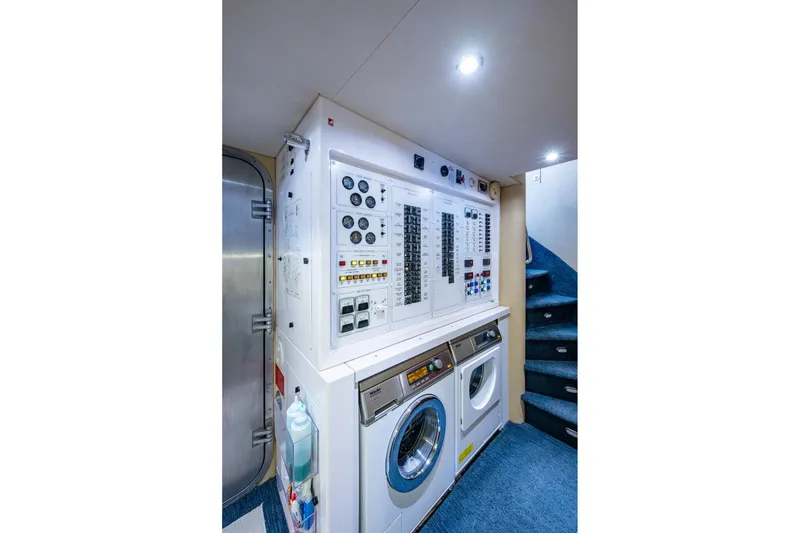 Slide: The Image of Laundry and control room aboard 2006 Westport 112 yacht, featuring washer, dryer, and control panel. - 110