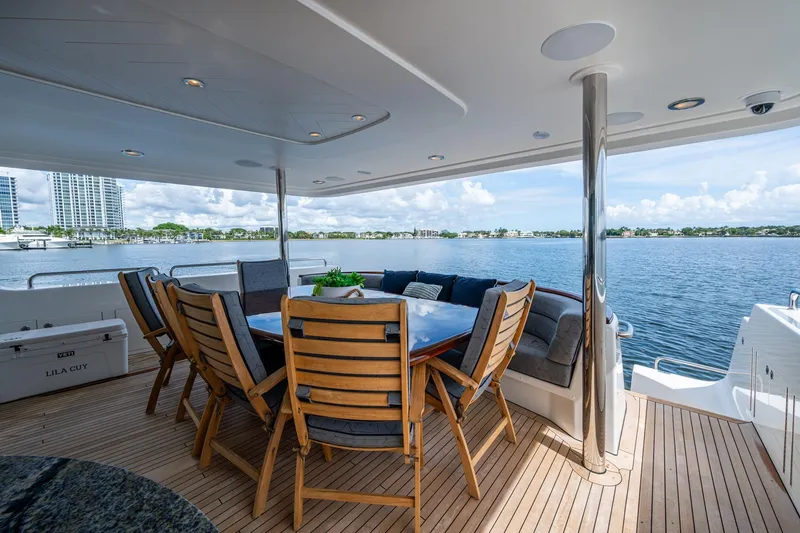 Slide: The Image of Luxurious 2006 Westport 112 yacht deck with dining area overlooking serene waterfront. - 95