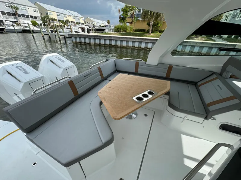 Slide: The Image of 2024 Beneteau Gran Turismo 32 yacht with sleek seating and modern design in a marina setting. - 14