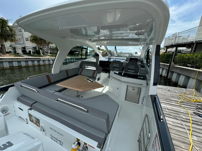 Slide: The Image of 2024 Beneteau Gran Turismo 32 yacht interior with seating and table, docked by the water. - 16