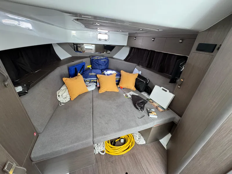Slide: The Image of 2024 Beneteau Gran Turismo 32 cabin with cushions, storage, and nautical equipment. - 18