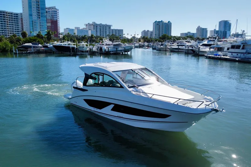 Slide: The Image of 2026 Beneteau Flyer 10 cruising in a marina with city skyline backdrop. - 4