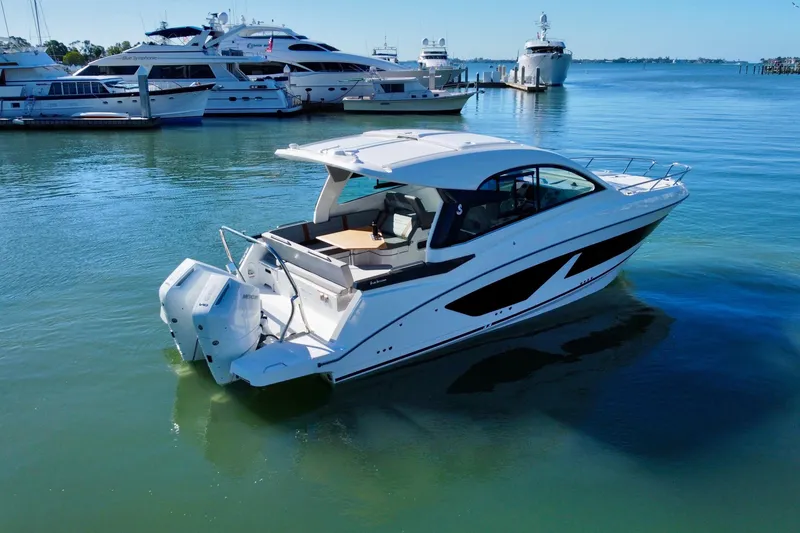 Slide: The Image of 2026 Beneteau Flyer 10 motorboat docked in a marina, surrounded by yachts. - 5
