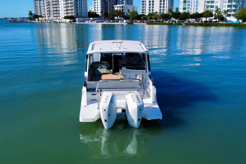 Slide: The Image of 2026 Beneteau Flyer 10 boat on calm water with cityscape background. - 6
