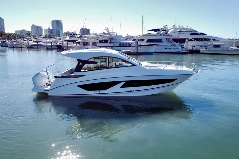 Slide: The Image of 2026 Beneteau Flyer 10 yacht docked in a marina with city skyline. - 7