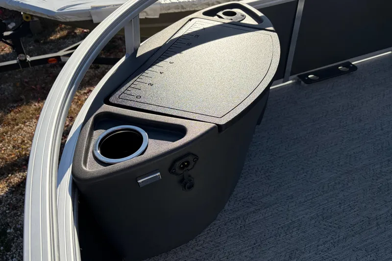 Slide: The Image of 2026 Sun Tracker Bass Buggy 18 DLX boat console with cup holder and measurement markings. - 19