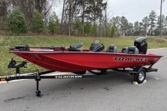 Slide: The Image of 2026 Tracker Pro Team 190 boat in red on a trailer, parked outdoors. - 3
