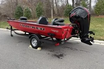 Slide: The Image of 2026 Tracker Pro Team 190 boat on trailer, red exterior, parked on road. - 6