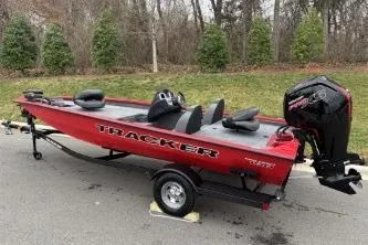 Slide: The Image of 2026 Tracker Pro Team 190 boat, red exterior, parked on trailer, outdoor setting. - 7