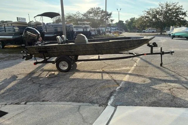 Slide: The Image of 2026 Tracker Grizzly 1754 SC boat on trailer in parking lot, side view. - 2