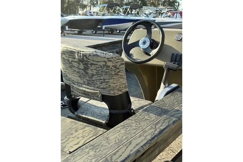 Slide: The Image of 2026 Tracker Grizzly 1754 SC boat interior with camo seat and steering wheel. - 3
