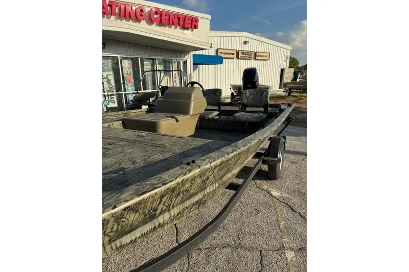 Slide: The Image of 2026 Tracker Grizzly 1754 SC boat displayed outside a boating center. - 4