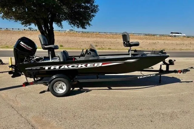 Slide: The Image of 2026 Tracker Pro 170 boat on trailer, parked outdoors under a tree. - 2