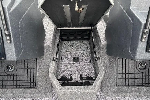Slide: The Image of 2026 Tracker Targa V-19 Combo boat storage compartment with open hatch and carpeted interior. - 13