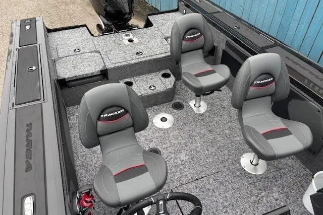 Slide: The Image of 2026 Tracker Targa V-19 Combo boat interior with four gray seats and carpeted flooring. - 21