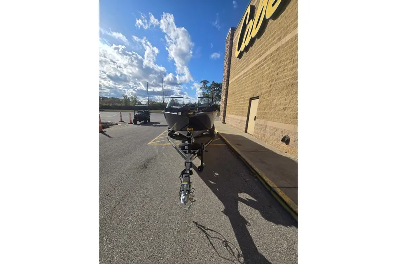 Slide: The Image of 2026 Tracker Pro Guide V-175 WT boat on trailer outside a store under a blue sky. - 71