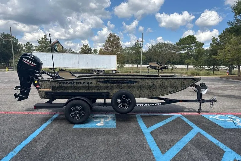 Slide: The Image of 2026 Tracker Grizzly 1650 T Prairie Wings Edition boat on trailer in parking lot. - 2