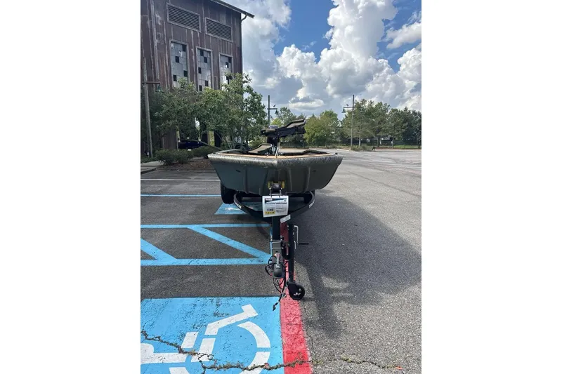 Slide: The Image of 2026 Tracker Grizzly 1650 T Prairie Wings Edition boat parked in a lot under cloudy sky. - 3