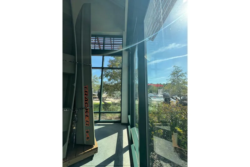 The Image of 2026 Tracker Grizzly 14 Jon boat displayed indoors with outdoor view. - 0