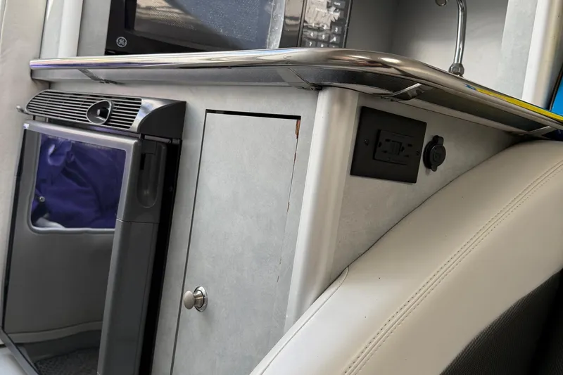 Slide: The Image of Interior of a 2005 Baja 30 Outlaw boat featuring a compact kitchenette area. - 14