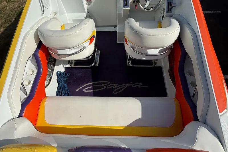 Slide: The Image of 2005 Baja 30 Outlaw boat interior with colorful seating and steering area. - 19