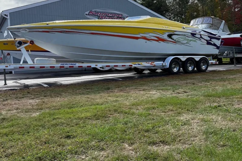 Slide: The Image of 2005 Baja 30 Outlaw speedboat on trailer, vibrant graphics, parked outdoors. - 5