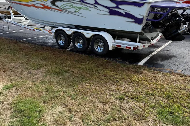 Slide: The Image of 2005 Baja 30 Outlaw boat on a trailer, featuring vibrant graphics and triple-axle wheels. - 6