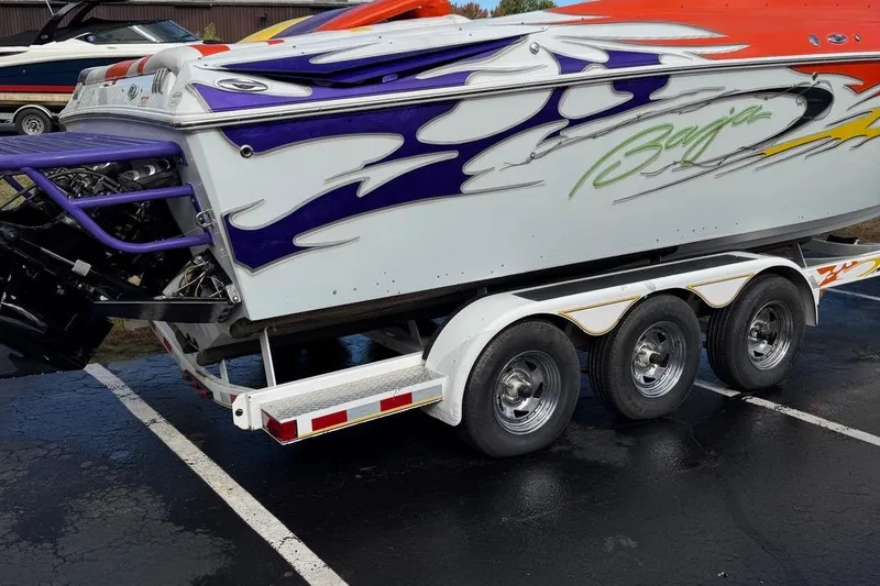 Slide: The Image of 2005 Baja 30 Outlaw boat on trailer with vibrant graphics and triple-axle wheels. - 7