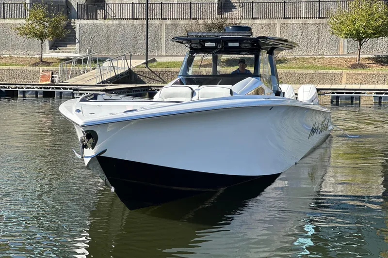 Slide: The Image of 2025 Nor-Tech 450 Sport Center Console boat docked in calm waters. - 10