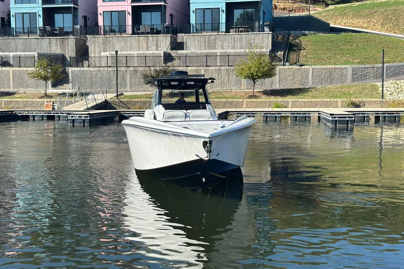 Slide: The Image of 2025 Nor-Tech 450 Sport Center Console boat docked near colorful buildings. - 11