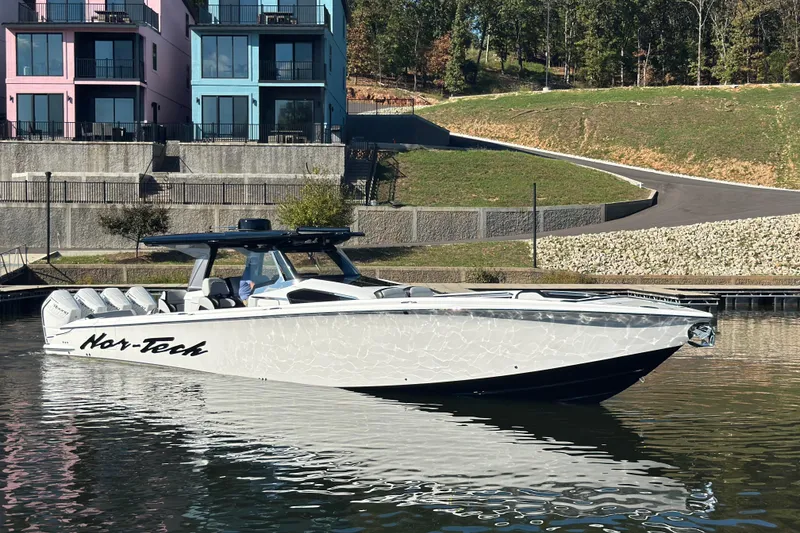 Slide: The Image of 2025 Nor-Tech 450 Sport Center Console boat docked near colorful buildings. - 13