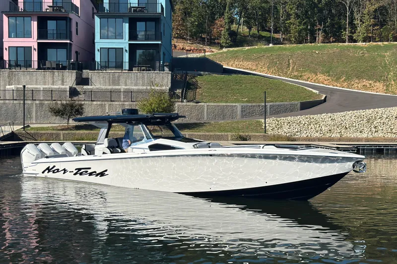 Slide: The Image of 2025 Nor-Tech 450 Sport Center Console boat docked near colorful buildings. - 14