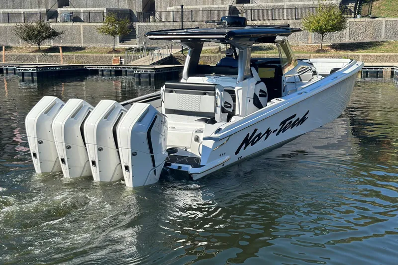 Slide: The Image of 2025 Nor-Tech 450 Sport Center Console boat with four powerful engines on a calm waterway. - 20