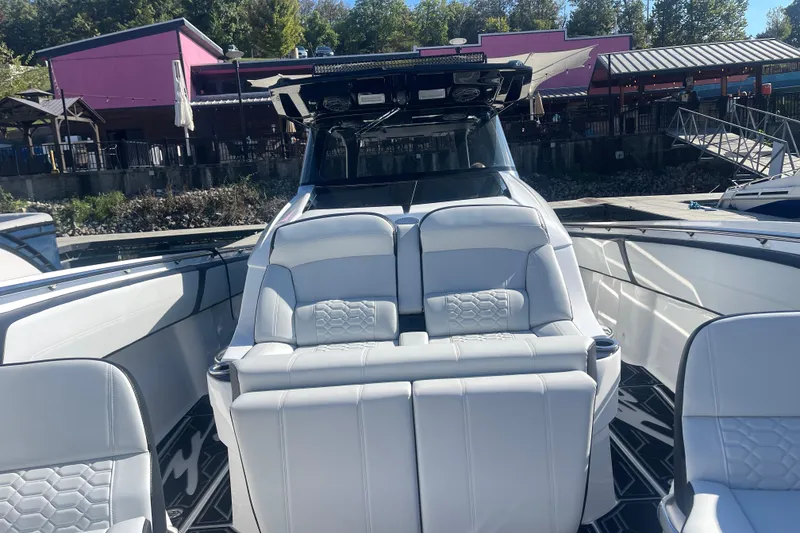 Slide: The Image of 2025 Nor-Tech 450 Sport Center Console with luxurious seating at a marina. - 35