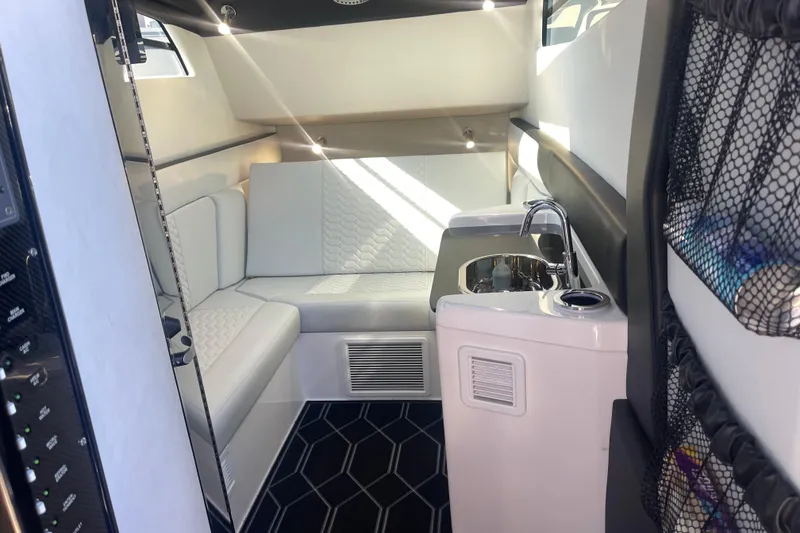 Slide: The Image of 2025 Nor-Tech 450 Sport Center Console interior with white seating and compact kitchenette. - 38