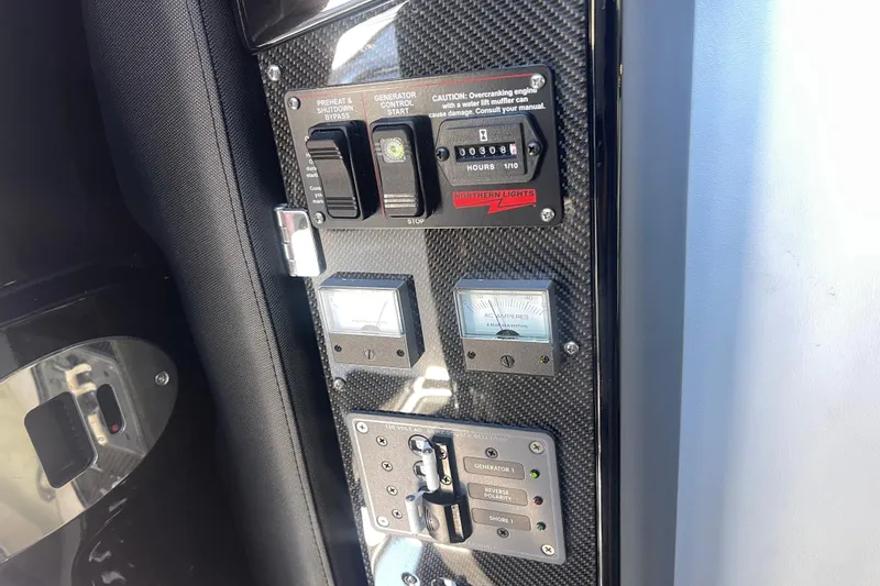 Slide: The Image of Control panel of 2025 Nor-Tech 450 Sport Center Console boat with generator switches. - 39
